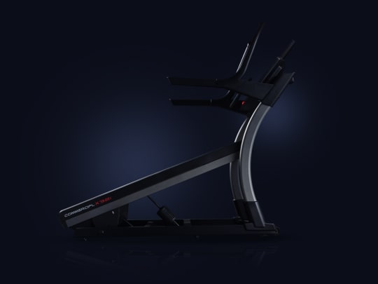 profile shot of treadmill that is inclined on a blue background.