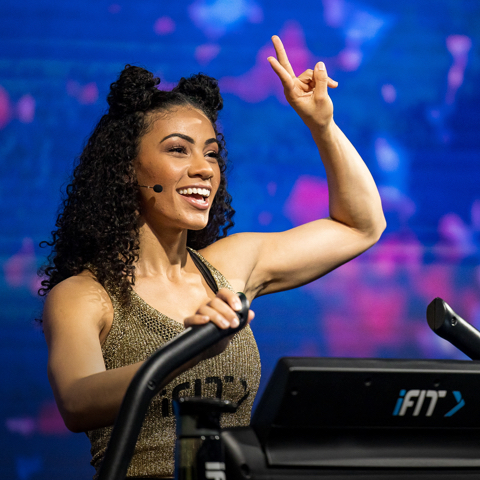 Coach smiling and holding up two fingers during workout.