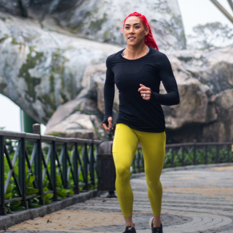 Trainer running across a bridge with snowy mountains in the background.
