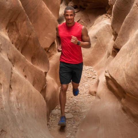 Coach running through the narrows of red rock.