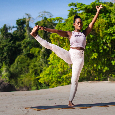 Trainer doing yoga pose with foot stretched outwards.