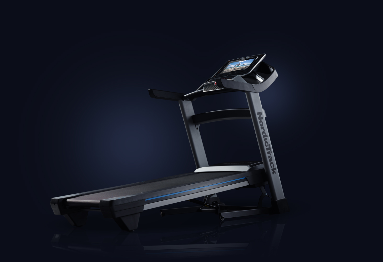 Profile shot of an inclined treadmill on dark blue gradient background
