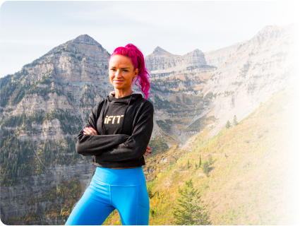 ifit trainer standing in the outdoors with a tall mountain in the background