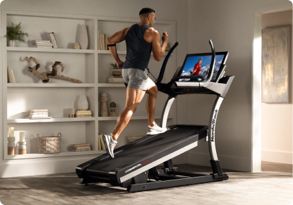 man running on a nordictrack incline treadmill in his home