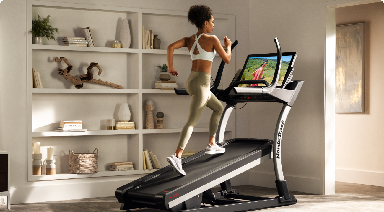 Woman running on a NordicTrack treadmill with an incline.