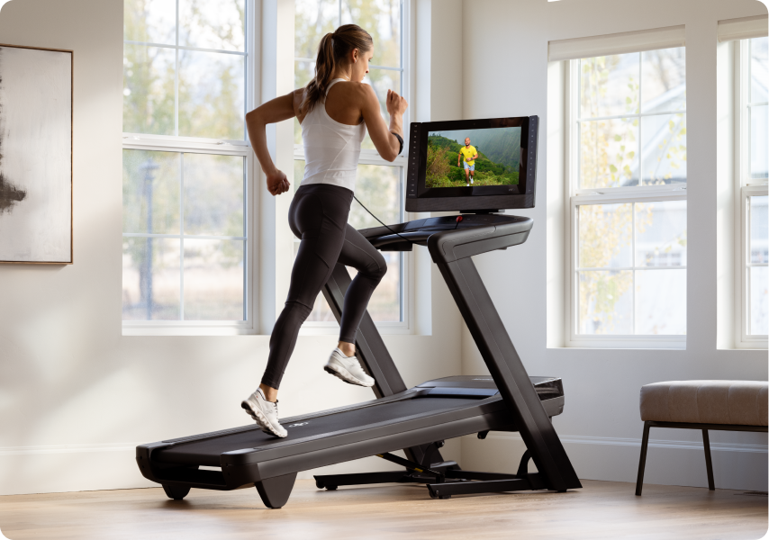 Woman running on a NordicTrack treadmill with an incline.