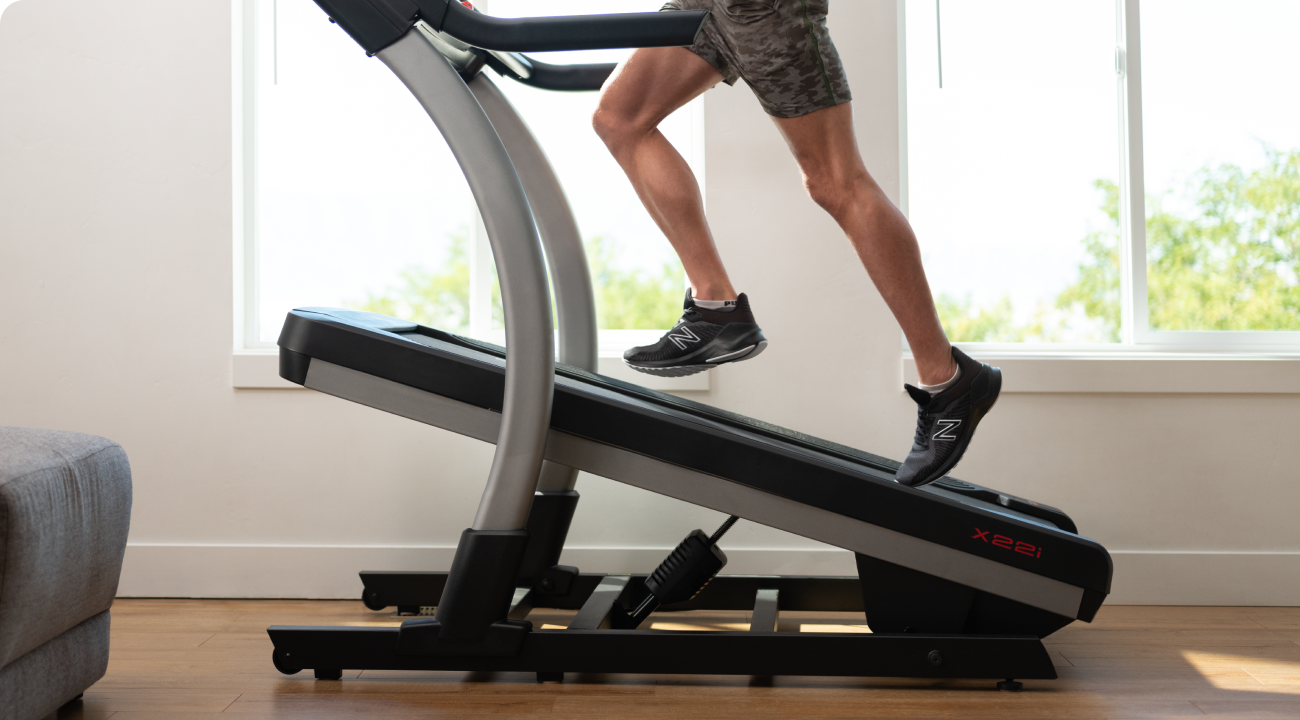 Man running on a NordicTrack treadmill with an incline.