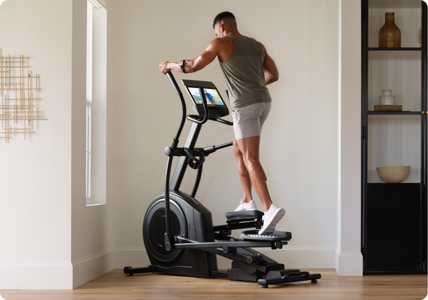 Man working out on a NordicTrack elliptical.